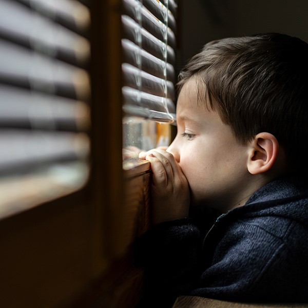 a child looking out from the covered window