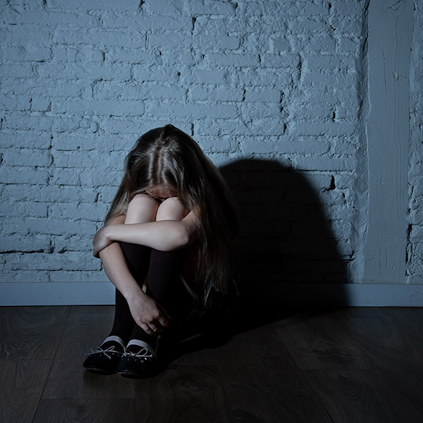 a little girl sadly sitting on the ground