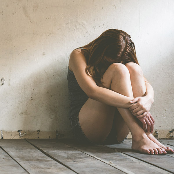 upset teen hugging her knees