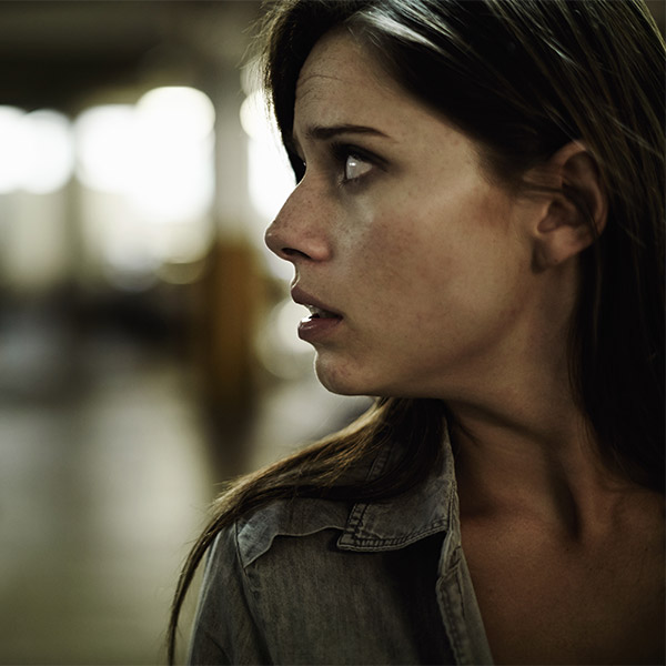scared woman looking over her shoulder